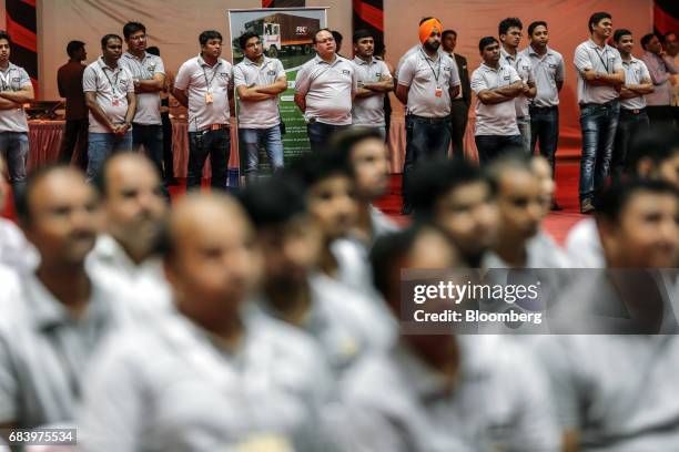 Employees watch as Nitin Gadkari, India's road and transport minister, not pictured, speaks during the inauguration of a conveyor at a warehouse...