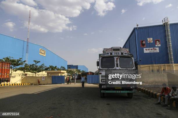 People walk outside warehouses operated by Future Supply Chain Solutions Ltd., left, and Patanjali Ayurved Ltd., right, near the Multi-modal...