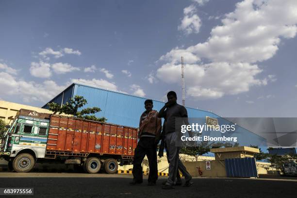 People walk outside a warehouse operated by Future Supply Chain Solutions Ltd. Near the Multi-modal International Cargo Hub Airport at Nagpur in...