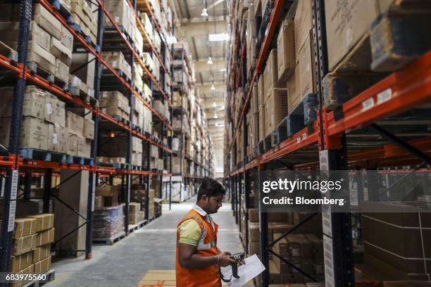 An employee uses a hand held scanner at a warehouse operated by Future Supply Chain Solutions Ltd. Near the Multi-modal International Cargo Hub...