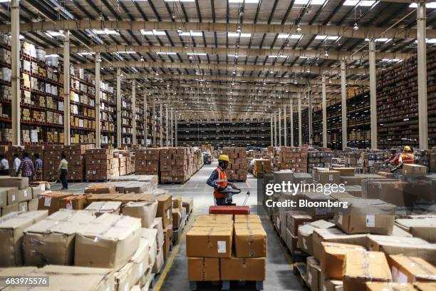 An employee pulls a pallet loaded with boxes at a warehouse operated by Future Supply Chain Solutions Ltd. Near the Multi-modal International Cargo...