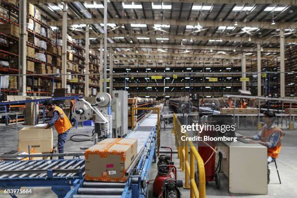 An employee uses a desktop computer as a colleague places merchandise into a box at a warehouse operated by Future Supply Chain Solutions Ltd. Near...