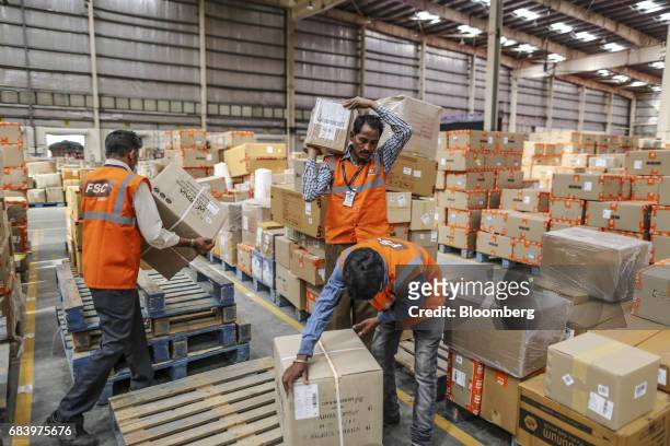 Employees carry boxes at a warehouse operated by Future Supply Chain Solutions Ltd. Near the Multi-modal Cargo International Hub Airport at Nagpur in...