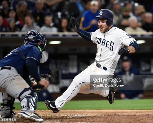 Matt Szczur of the San Diego Padres is tagged out at the plate by Manny Pina of the Milwaukee Brewers during the seventh inning of a baseball game at...