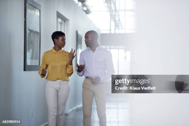 businesspeople having conversation, while on the way to a meeting - people talking in office corridor stock pictures, royalty-free photos & images