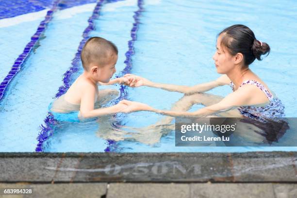 kid learns swimming with his mother - leren 個照片及圖片檔