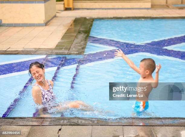 mother and kid splashing in swimming pool - leren 個照片及圖片檔