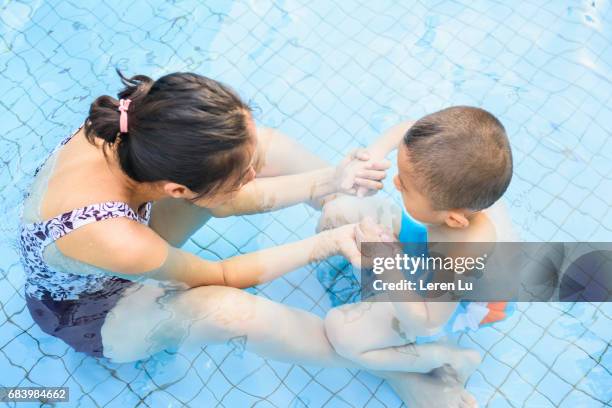 kid learns swimming with his mother - leren 個照片及圖片檔