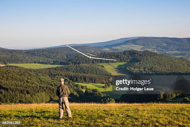 man and model airplane on wasserkuppe mountain - hesse stock pictures, royalty-free photos & images