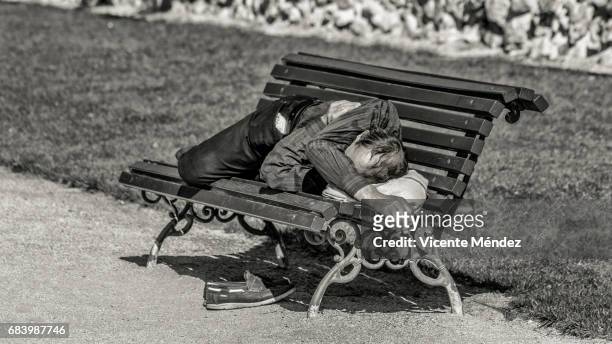 sleeping on a bench in the sun - parque público 個照片及圖片檔