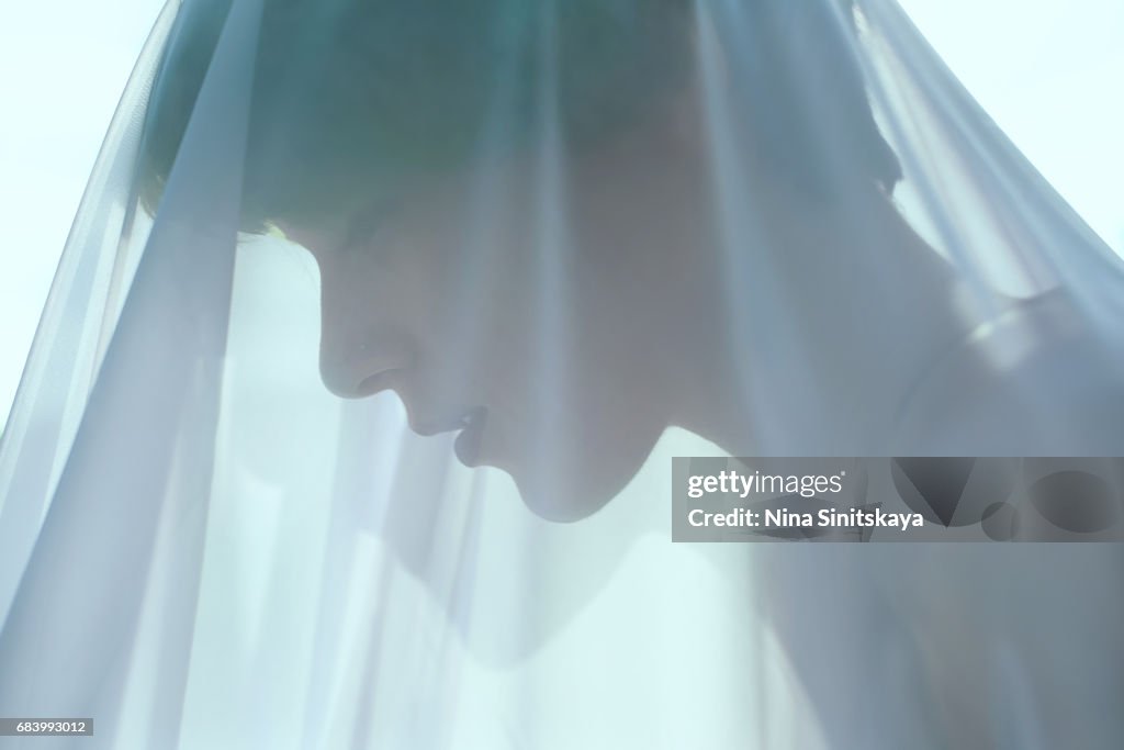 Profile of woman with green hair under blue veil