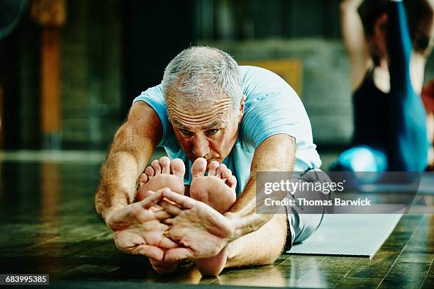 Man in seated forward bend pose during yoga class