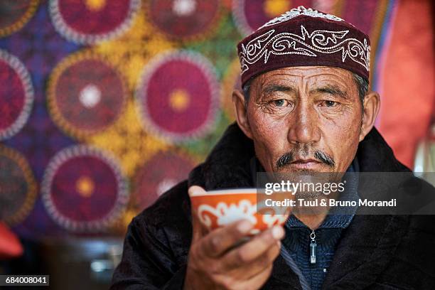 mongolia, kazakh man drinking a tea - gorra a modo de casquete fotografías e imágenes de stock