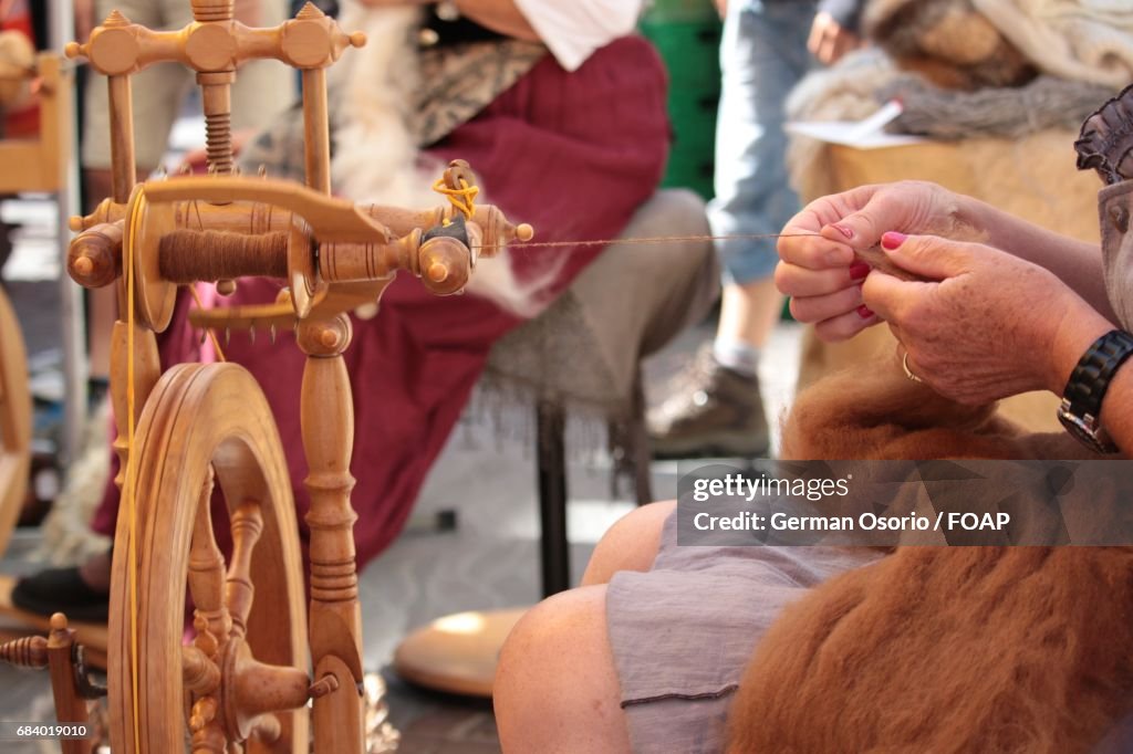 Woman spinning wheel to make yarn