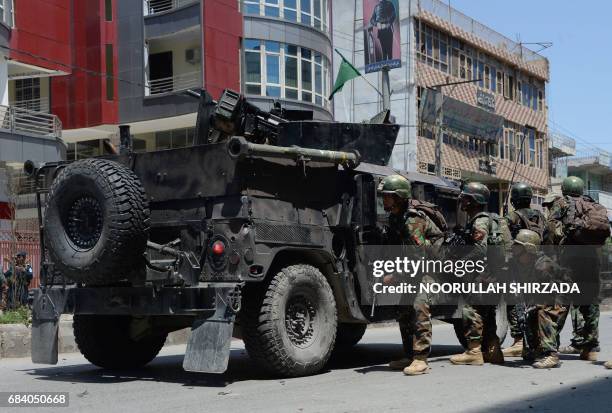 Afghan security forces take up a position at the site of suicide bombing in Jalalabad on May 17, 2017. Suicide bombers stormed the national...