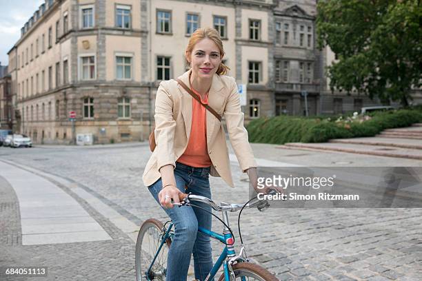 portrait of young woman with bicycle in the city - green blazer stockfoto's en -beelden