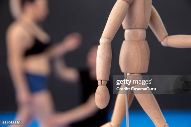 therapist showing on the wodden mannequin how to improve the posture - boa postura imagens e fotografias de stock