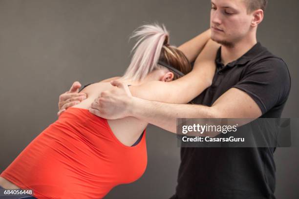 therapist showing postural dysfunction corrective exercises - postural stock pictures, royalty-free photos & images