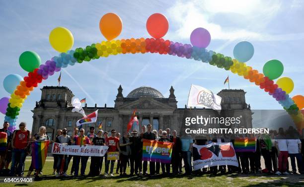Activists of the LGBT movement hold up a balloon chain in rainbow colors as they demonstrate against homophobia and transphobia in front of the...
