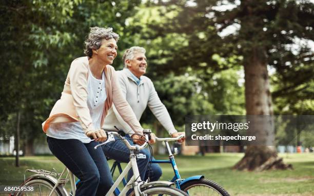il n’y a rien de mieux que d’apprécier une balade à vélo ensemble - senior dynamique photos et images de collection