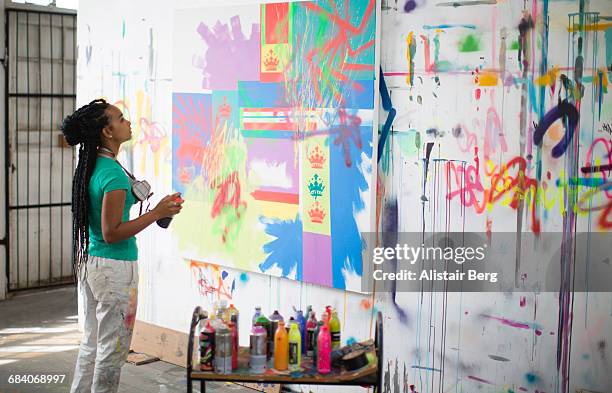 young female artist working in her studio - graffiti ストックフォトと画像