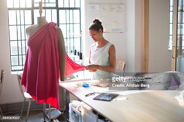 young clothes designer in her studio - stilista di moda foto e immagini stock