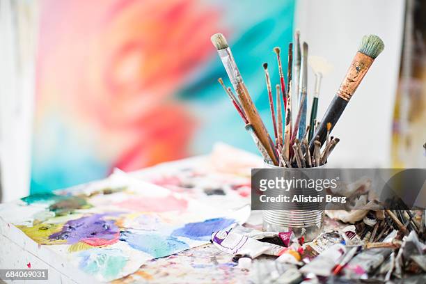 paints and paint brushes in an artists studio - kunst und kunsthandwerk stock-fotos und bilder