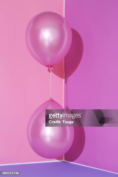 Opposing pink balloons on pink background