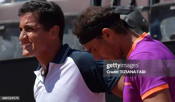 Nicolas Almagro of Spain grimaces after an injury as Rafael Nadal of Spain looks on during their match at the ATP Tennis Open tournament on May 17,...