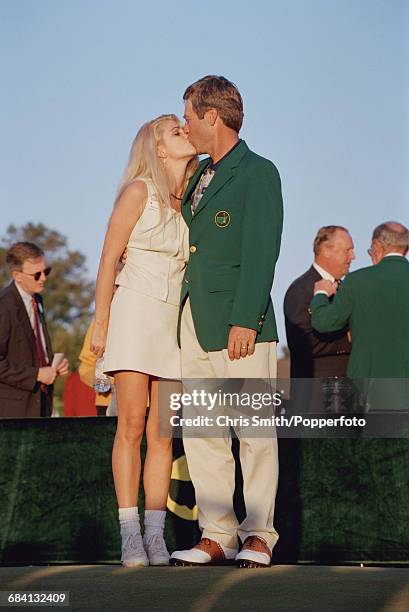 American golfer Ben Crenshaw kisses his wife Julie Crenshaw afer being presented with his green jacket by the previous year's winner, Spanish golfer...