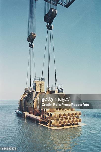 View of United States Navy SEALAB III underwater habitat vessel being lowered in to the Pacific Ocean by a crane off the coast of California, United...