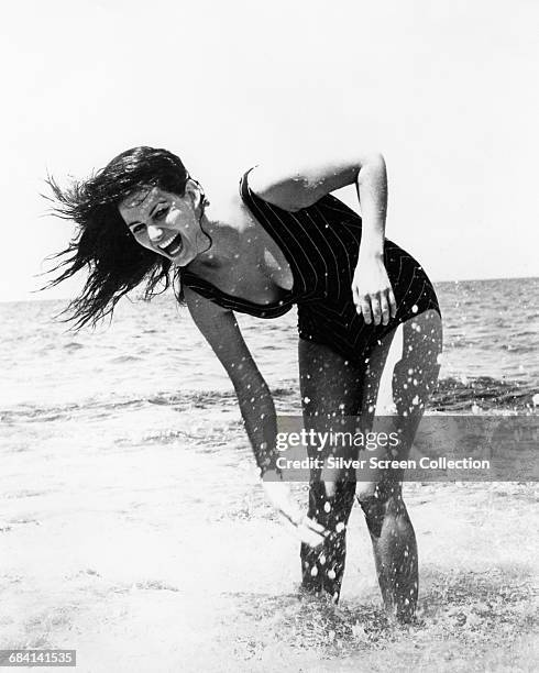 Italian actress Claudia Cardinale on the beach, circa 1960.