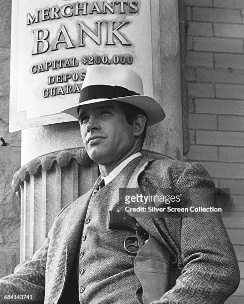 Actor Warren Beatty as bank robber Clyde Barrow, standing outside the Merchants Bank in the film 'Bonnie and Clyde', 1967.