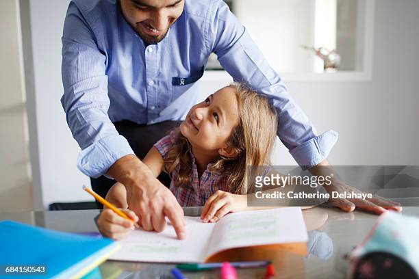 a 7 years old girl doing her homework with her dad - 8 9 years stock pictures, royalty-free photos & images