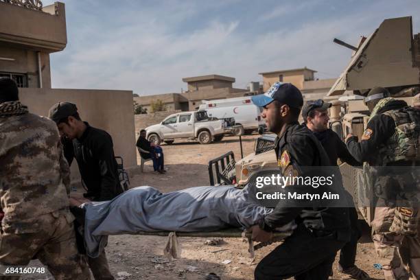 Iraqi Counter Terrorism Service soldiers carry an injured civilian from a humvee into a field hospital in the Mosul district of Al-Samah.