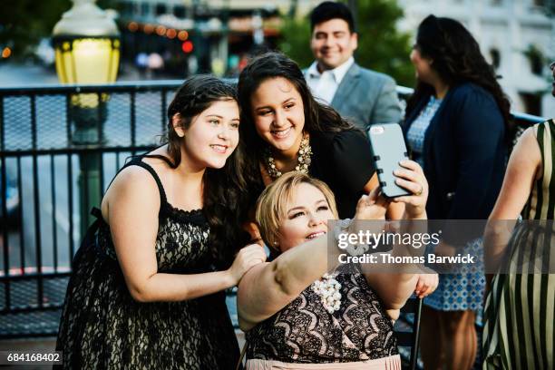 mother taking selfie on smartphone with two daughters on restaurant deck - large family stock photos et images de collection