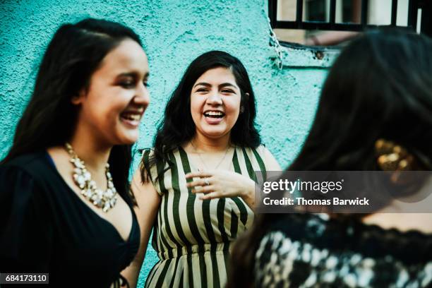 Friends laughing together during dinner on restaurant deck