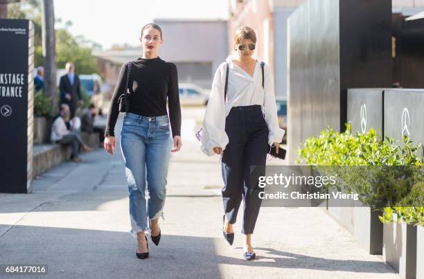 Sara Donaldson wearing a black knit, blue denim jeans, heels and Talisa Sutton wearing a white button shirt with wide sleeves, navy pants, black bag...