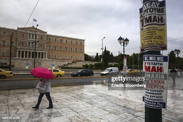 Pedestrian walks past placards promoting a 24-hour labour strike outside the parliament building on Syntagma Square in Athens, Greece, on Wednesday,...