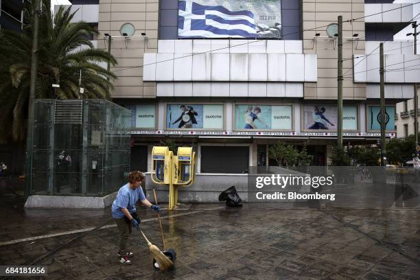 Municipal worker cleans a sidewalk in a central square in Athens, Greece, on Wednesday, May 17, 2017. Greeces economy returned to recession in the...