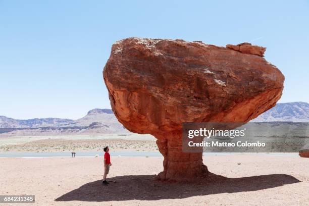 man standing under balancing rock, utah, usa - conceptualrealismtrend stock-fotos und bilder