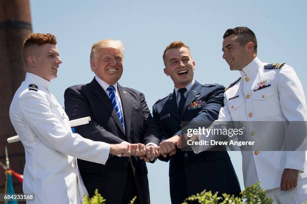 President Donald Trump poses with Coast Guard cadets as he hands out diplomas at the commencement ceremony for the U.S. Coast Guard Academy, May 17,...
