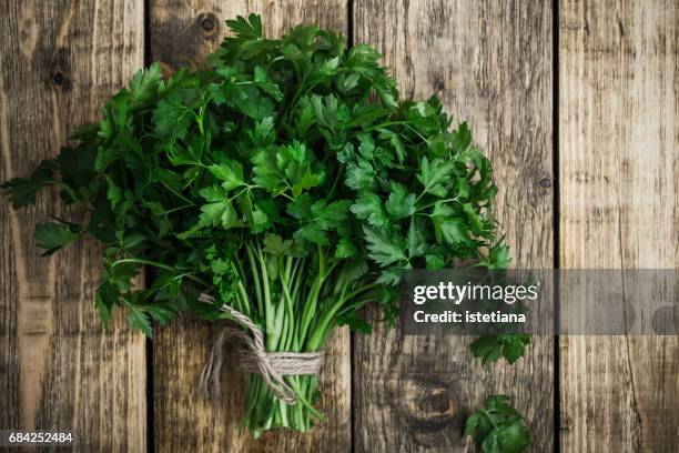 fresh organic parsley over wooden background - parsley stock-fotos und bilder