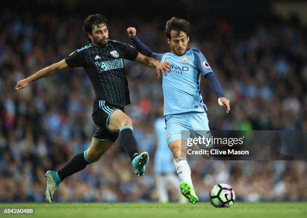 David Silva of Manchester City shoots past Claudio Yacob of West Bromwich Albion during the Premier League match between Manchester City and West...