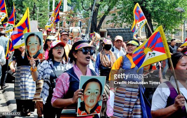 Exile Tibetan and Buddhist nuns carry placards and national flag during a protest march demanding the release of their religious leader Gedhun...