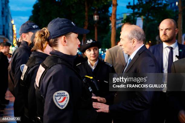 Newly appointed French Interior Minister Gerard Collomb speaks with police officers during a visit to the Champs-Elysees avenue in Paris on May 17 as...