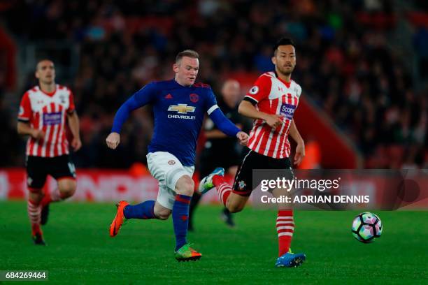 Manchester United's English striker Wayne Rooney chases the ball under pressure from Southampton's Japanese defender Maya Yoshida during the English...