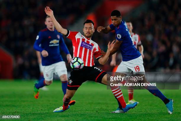 Manchester United's English striker Marcus Rashford battles with Southampton's Japanese defender Maya Yoshida during the English Premier League...