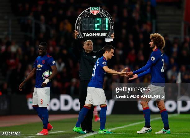 Manchester United's Belgian midfielder Marouane Fellaini goes off to be replaced by Manchester United's Spanish midfielder Ander Herrera during the...