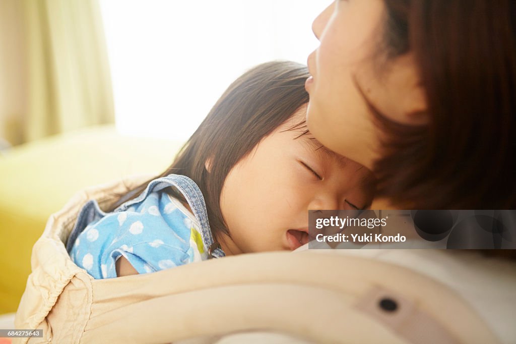 Baby sleeping in a mother holding it.